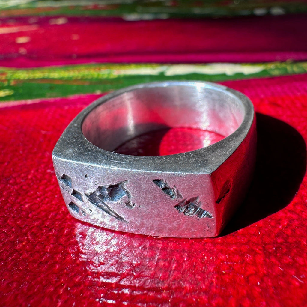 Tally signet ring, curved flat face with dark patina in the cuts